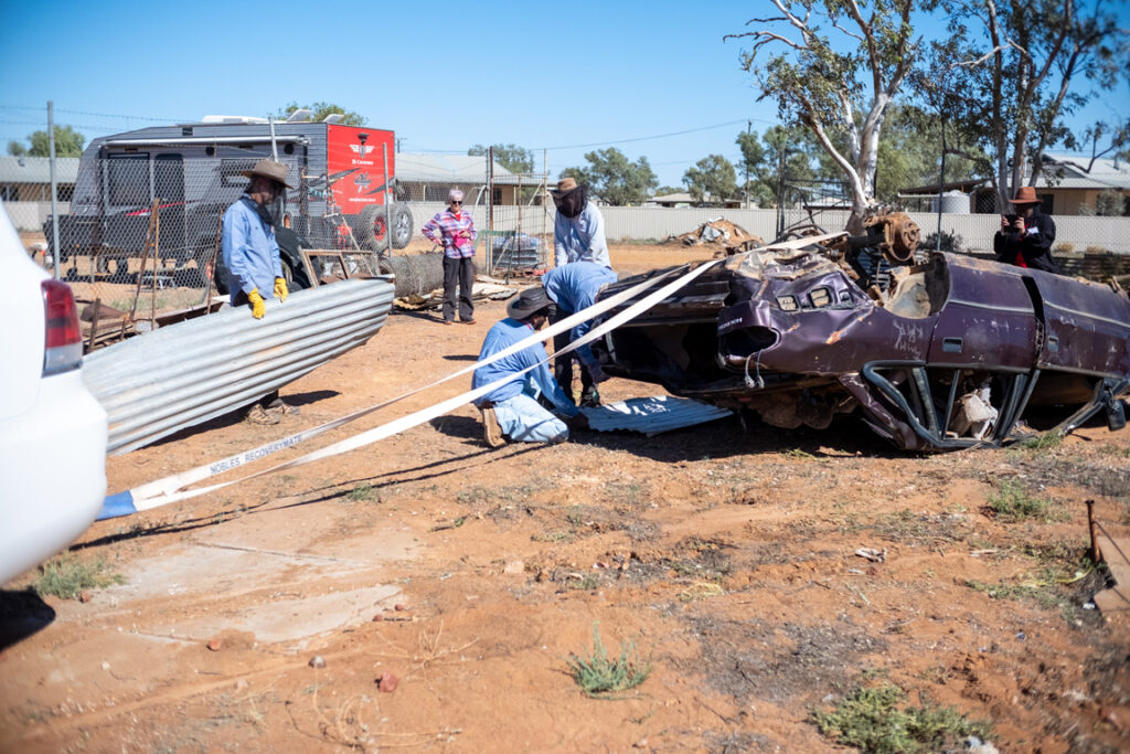 Obl volunteers and fs staff towing an old car wreck to clear space